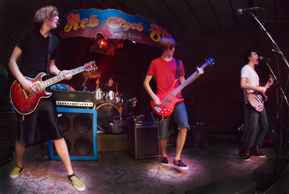 The band performing on a small stage beneath a Red Eyed Fly sign.